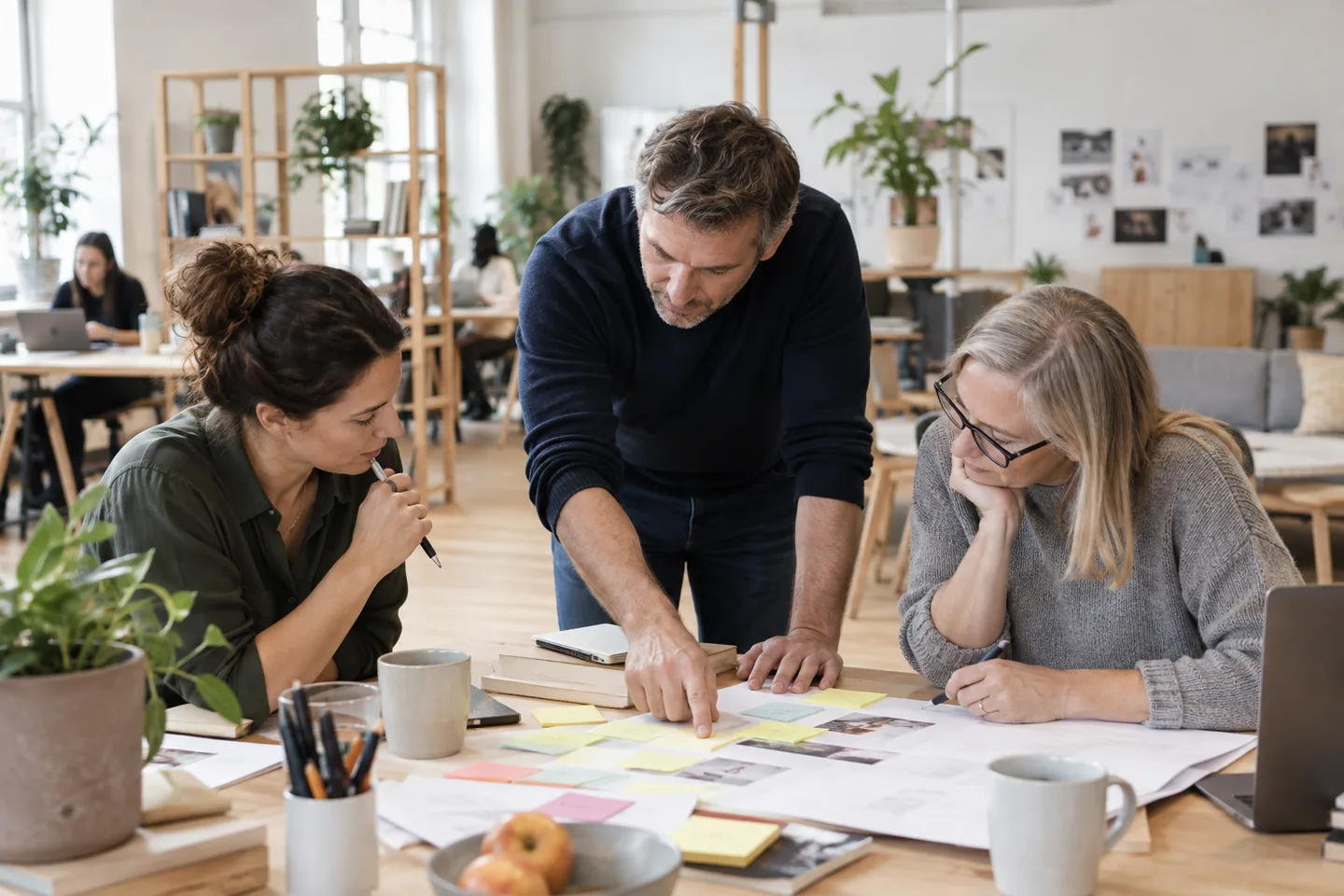 A professional returning to work contributes to a project with two colleagues.